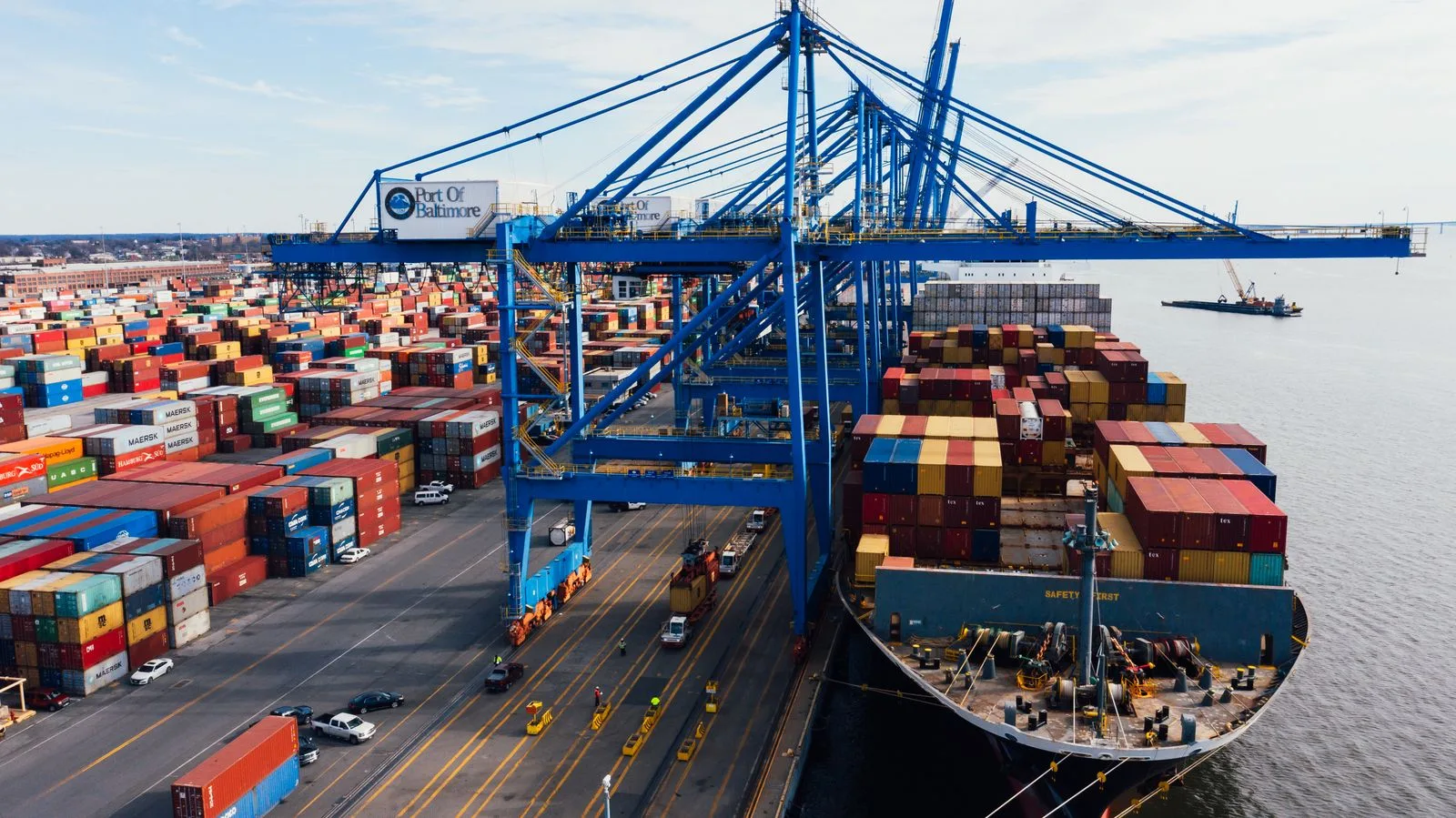 Porte-conteneurs à quai sous les grues d'un port de commerce, transport maritime de marchandises